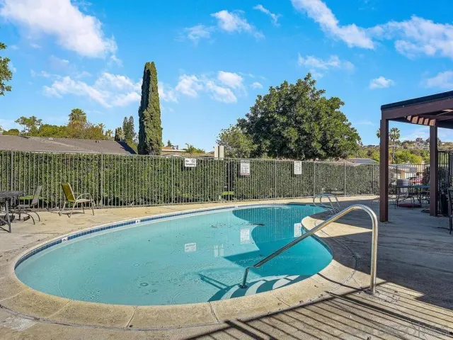 a view of a swimming pool with a patio and a yard