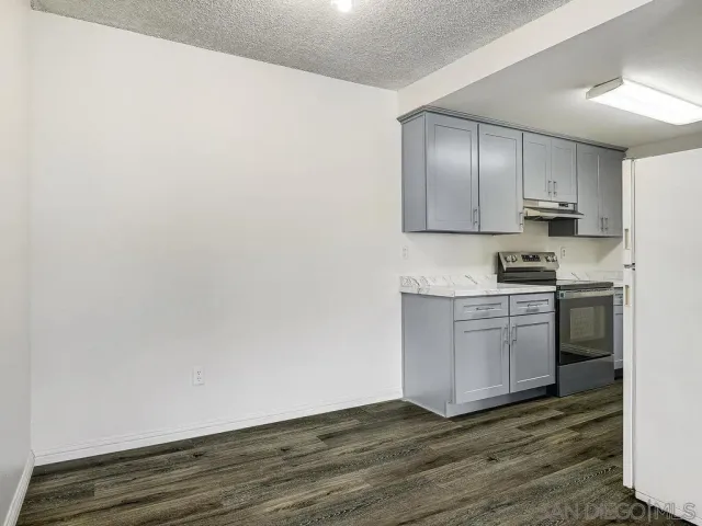 a kitchen with granite countertop white cabinets and white appliances