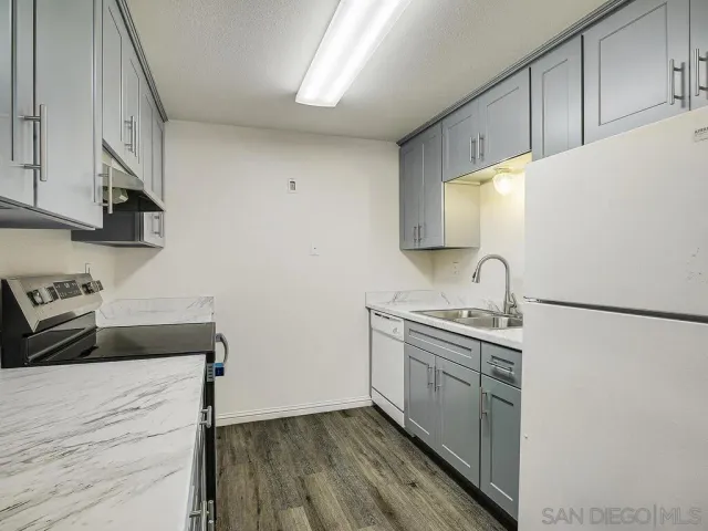 a kitchen with stainless steel appliances a stove a sink and a refrigerator