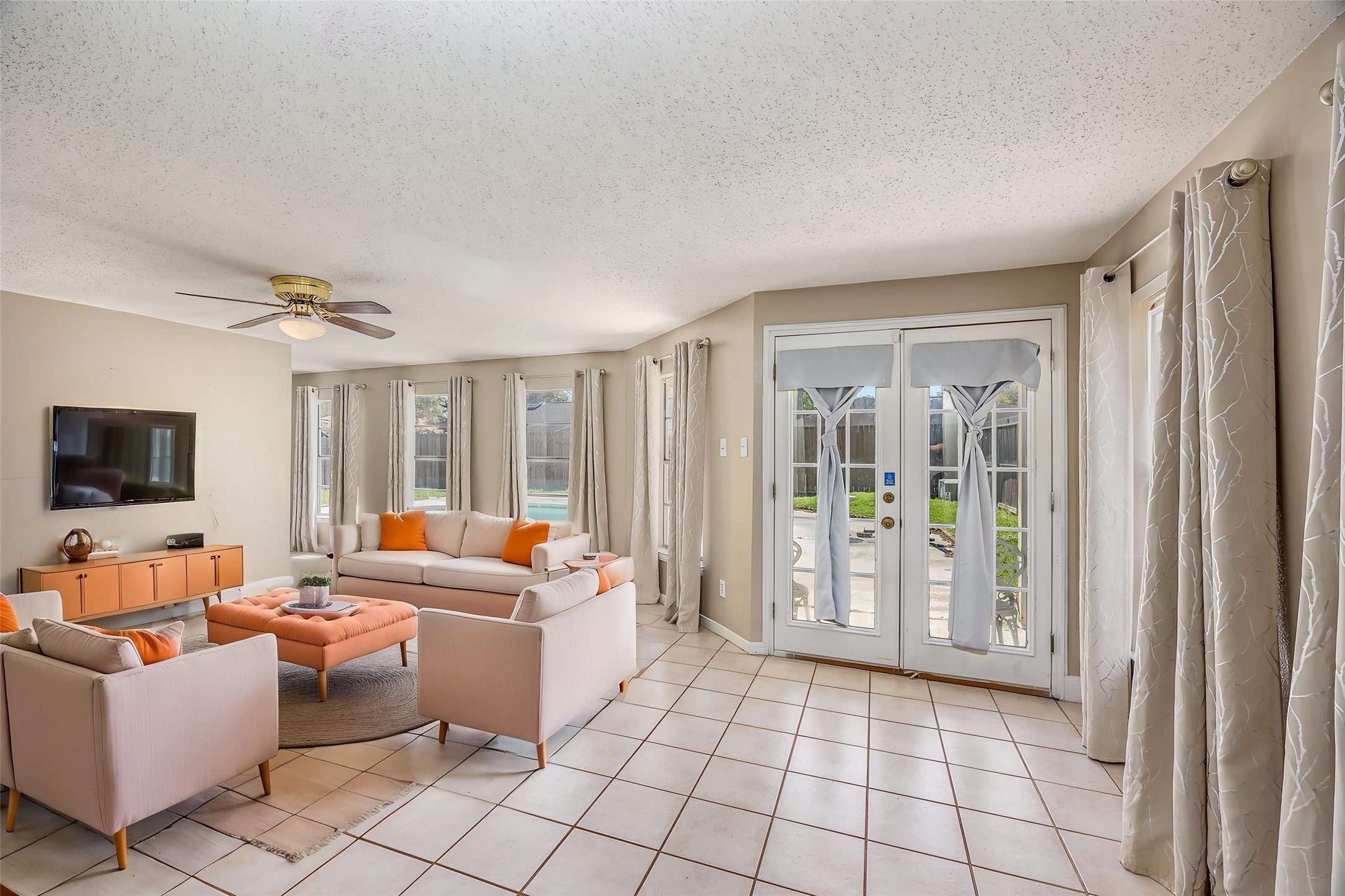 1603 East Baker Road Baytown, TX 77521 - Photo 12 of 26 Bright and inviting secondary living room with large windows, French doors leading to a patio, and neutral tile flooring.