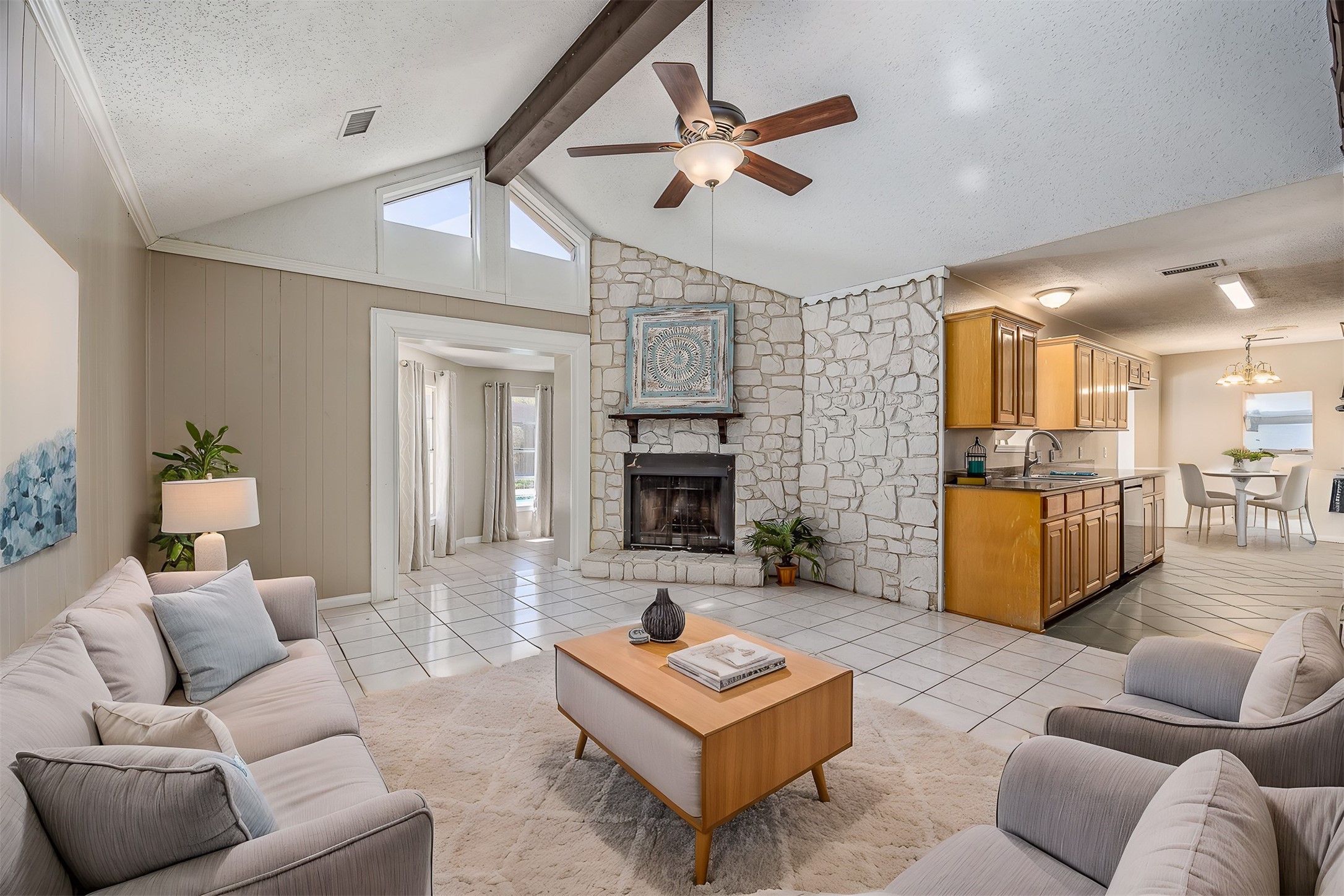 1603 East Baker Road Baytown, TX 77521 - Photo 4 of 26 This spacious living area features a vaulted ceiling with exposed beams, a cozy stone fireplace, and abundant natural light. The open layout connects to a modern kitchen with wooden cabinetry, and a dining area, perfect for entertaining. Neutral tones and tiled floors add a contemporary touch.
Virtually staged.