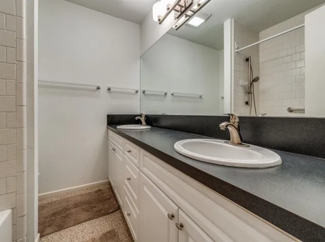 a bathroom with a double vanity sink and a mirror