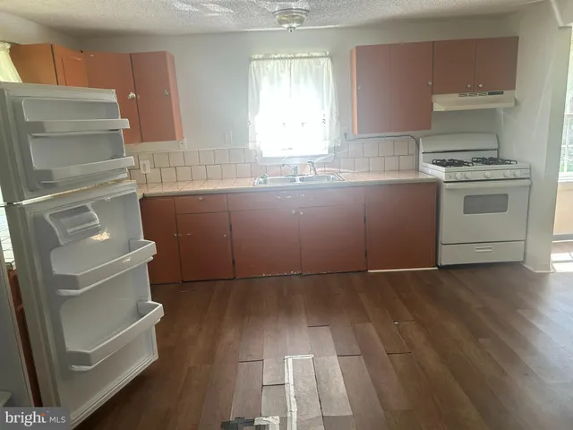 a kitchen with granite countertop a refrigerator and a stove