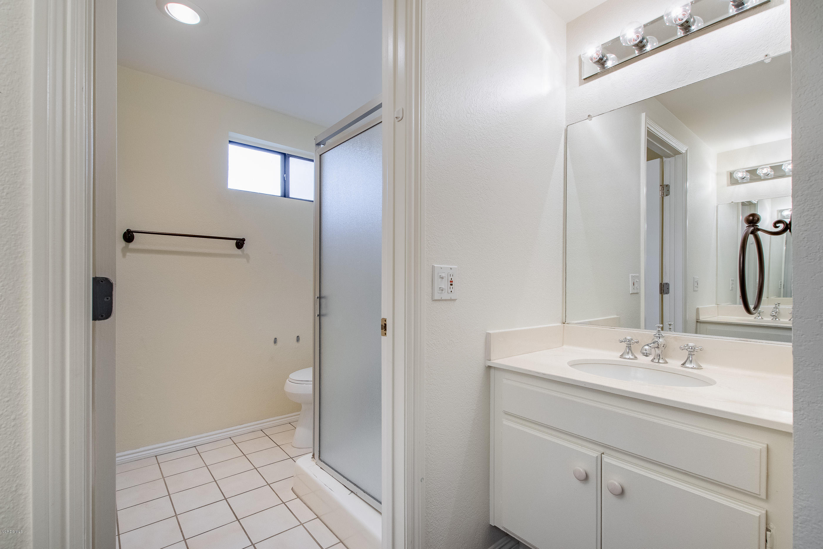 17914 West Magnolia Boulevard, Unit 316 Encino, CA 91316 - Photo 13 of 21 a bathroom with a sink mirror and a toilet