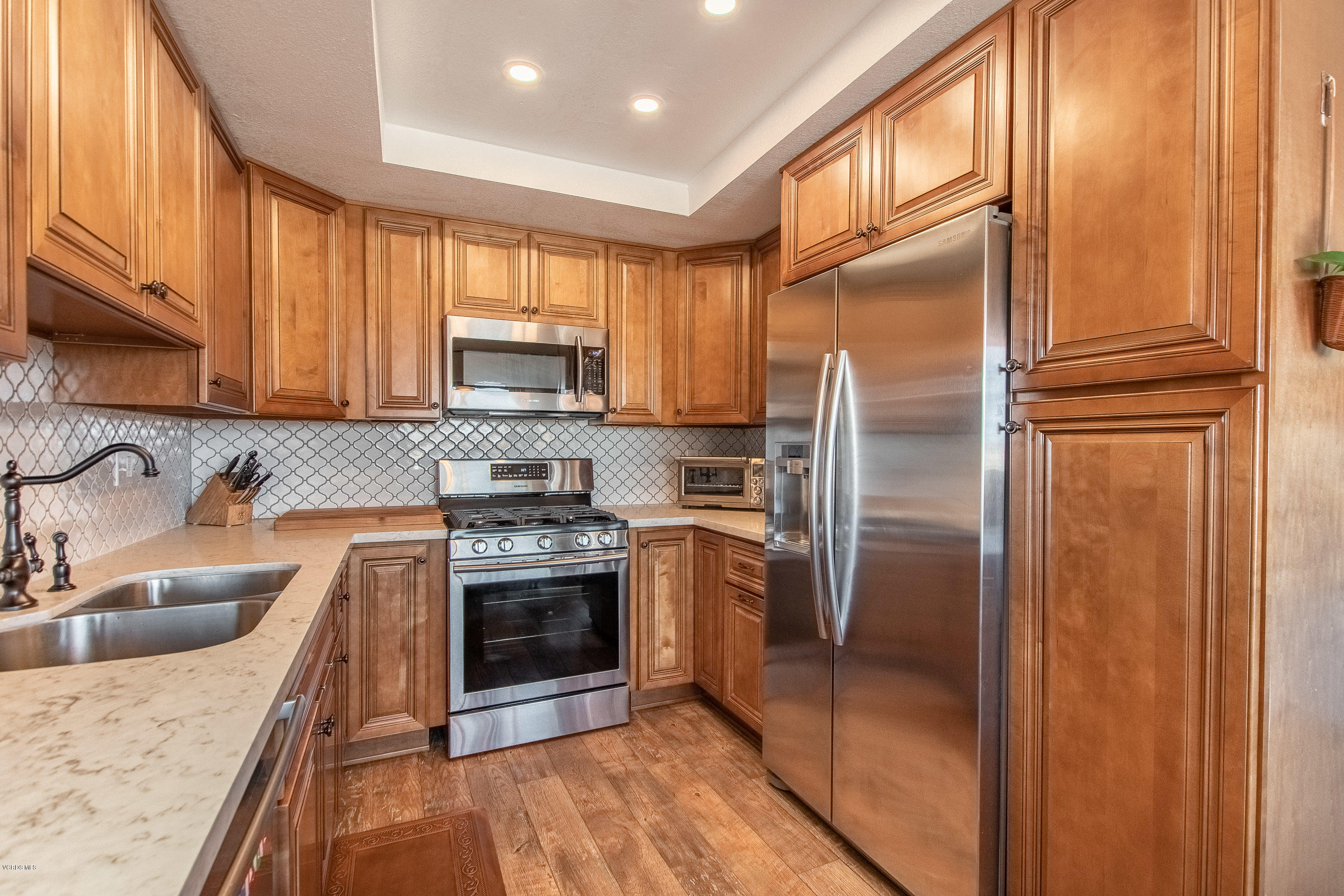 17914 West Magnolia Boulevard, Unit 316 Encino, CA 91316 - Photo 7 of 21 a kitchen with stainless steel appliances granite countertop a refrigerator stove and sink