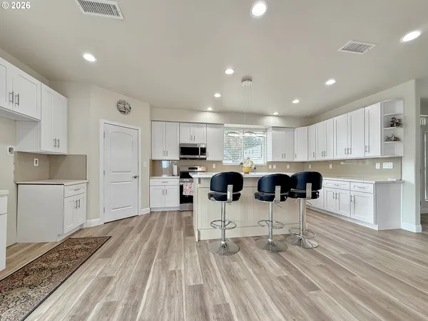 a kitchen with a table chairs refrigerator and cabinets