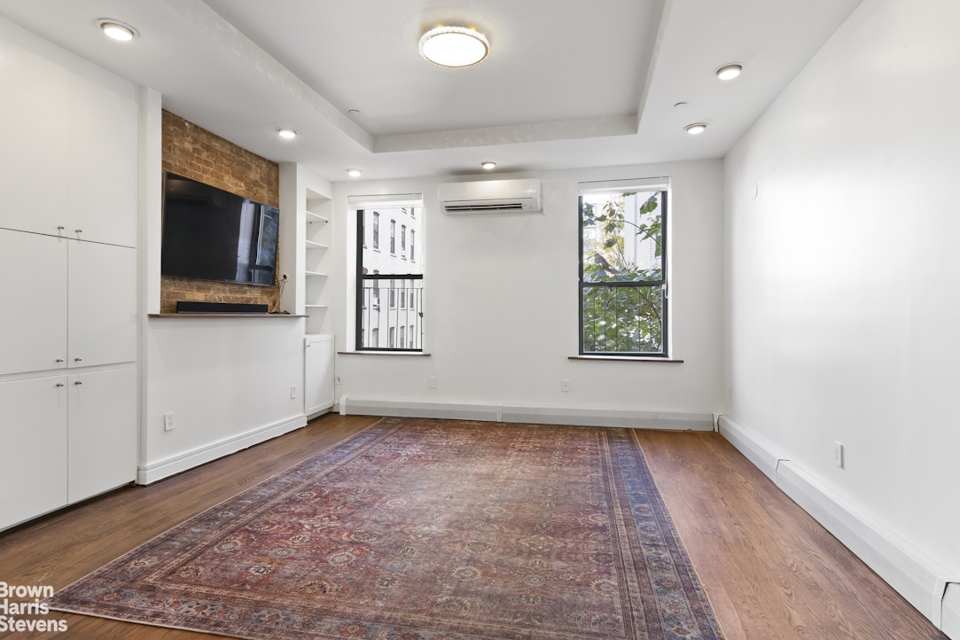167 West 136th Street, Unit 4 Manhattan, NY 10030 - Photo 1 of 8 a view of an empty room with a window and wooden floor