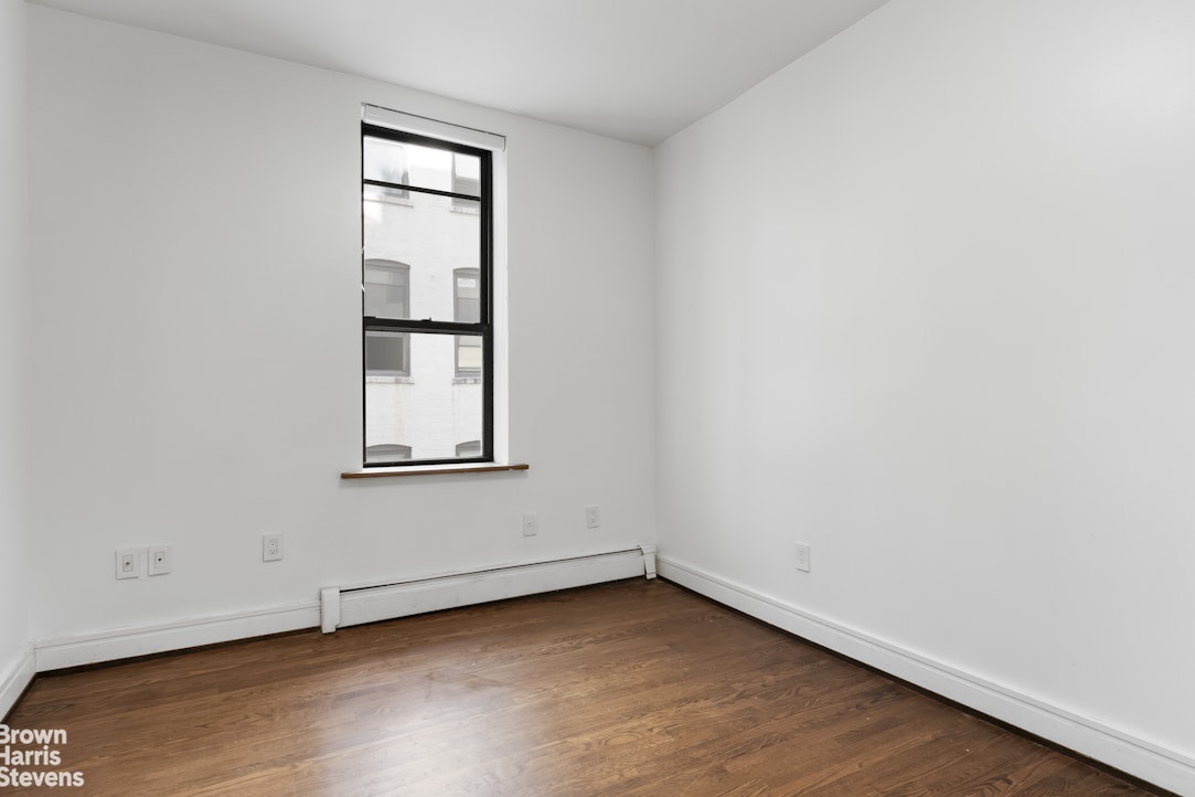 167 West 136th Street, Unit 4 Manhattan, NY 10030 - Photo 5 of 8 an empty room with wooden floor and windows