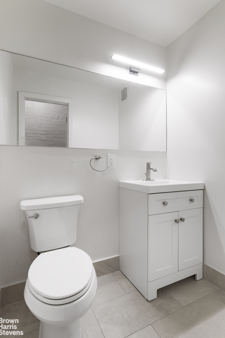 167 West 136th Street, Unit 4 Manhattan, NY 10030 - Photo 6 of 8 a bathroom with a toilet sink and mirror