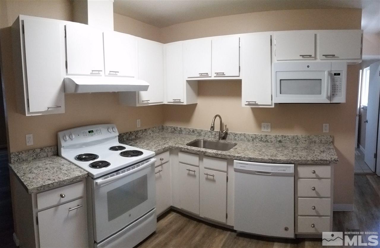 945 Beldon Way Reno, NV 89503 - Photo 4 of 20 a kitchen with granite countertop a sink a stove and cabinets