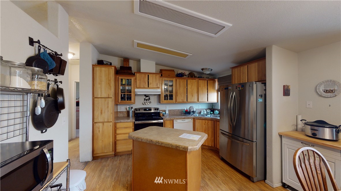 196 Skyrocket Road Prescott, WA 99348 - Photo 8 of 21 a kitchen with a refrigerator a stove top oven a sink and wooden floor