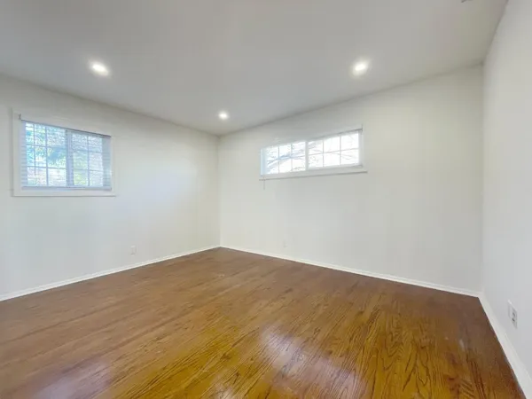 a view of empty room with wooden floor