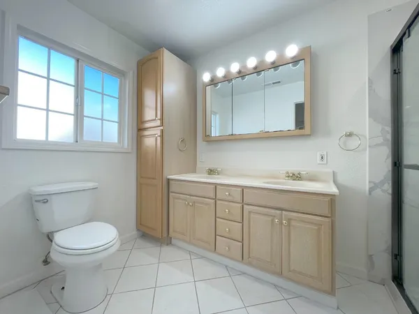 a spacious bathroom with a toilet sink and mirror