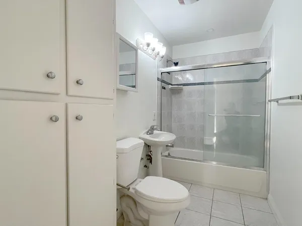 a bathroom with a shower a toilet and a sink