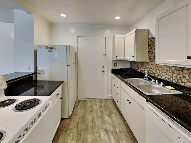 a kitchen with granite countertop a sink and a stove top oven