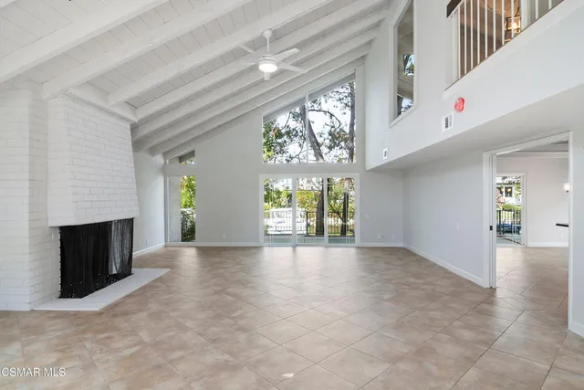 a view of an empty room with a fireplace and a window