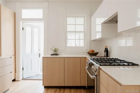 a kitchen with stainless steel appliances a sink a stove and white cabinets