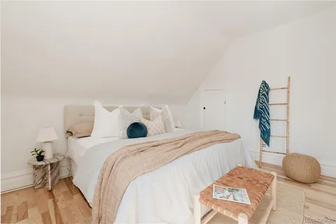 a bedroom with a bed and a painting on the wall