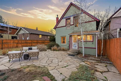 a view of a house with backyard and sitting area
