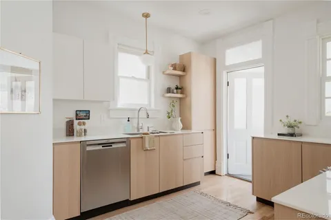 a kitchen with white cabinets sink and refrigerator
