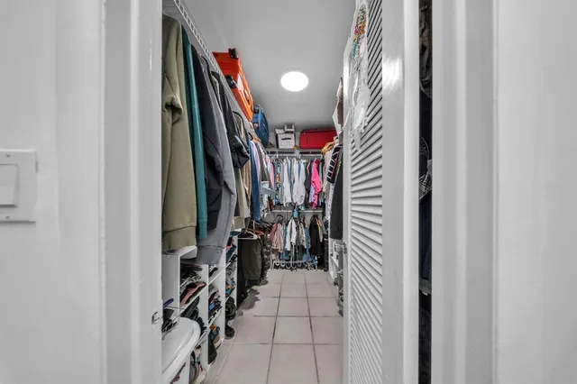 a living room with furniture floor to ceiling window and a flat screen tv