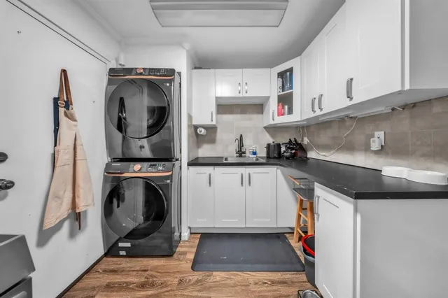 a kitchen with stainless steel appliances granite countertop a refrigerator a stove and a sink with wooden floor