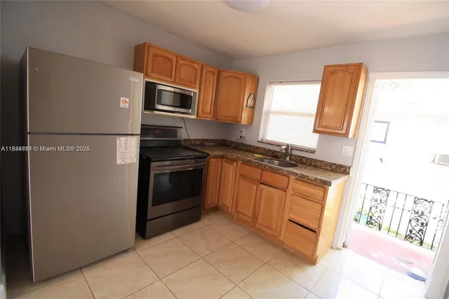 a kitchen with stainless steel appliances granite countertop a refrigerator sink and stove