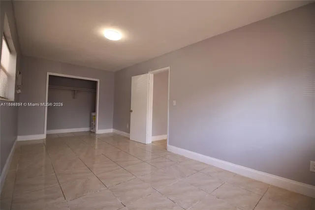 an empty room with closet and a window