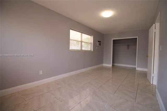 an empty room with windows and entrance to other room