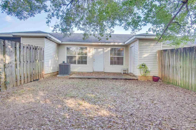 a view of a house with a backyard and a tree