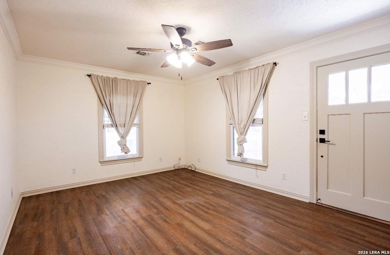 149 South Carroll Street Poth, TX 78147 - Photo 2 of 22 an empty room with wooden floor fan and windows