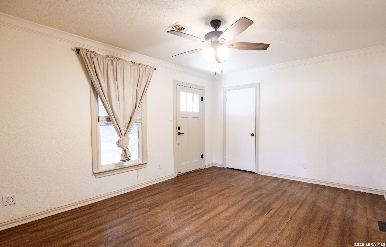 149 South Carroll Street Poth, TX 78147 - Photo 3 of 22 an empty room with wooden floor chandelier fan and windows