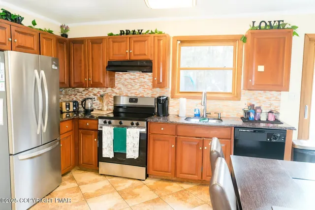 a kitchen with stainless steel appliances granite countertop a refrigerator sink and cabinets