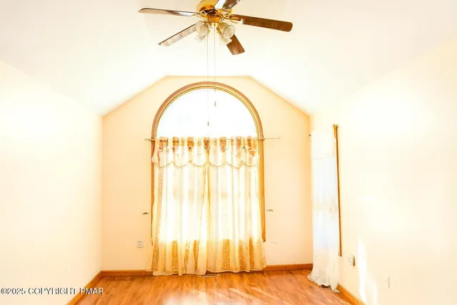 a view of a big room with wooden floor and windows