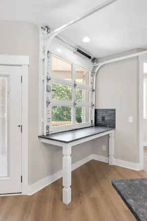 a living room with a table and windows