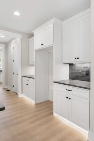 a kitchen with granite countertop white cabinets and white appliances