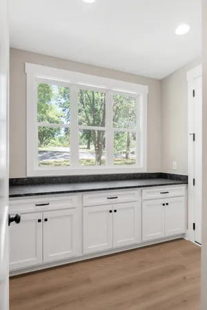 a kitchen with granite countertop white cabinets and a large window