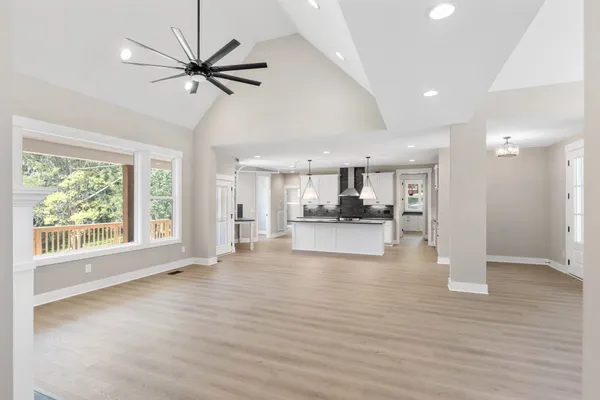 a view of an empty room with a window and wooden floor