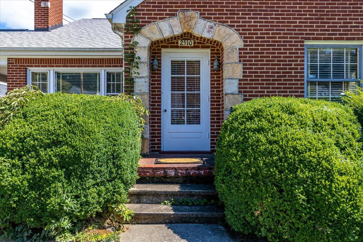 2510 Tillett Road Southwest Roanoke, VA 24015 - Photo 3 of 27 a view of a brick house with plants and large windows