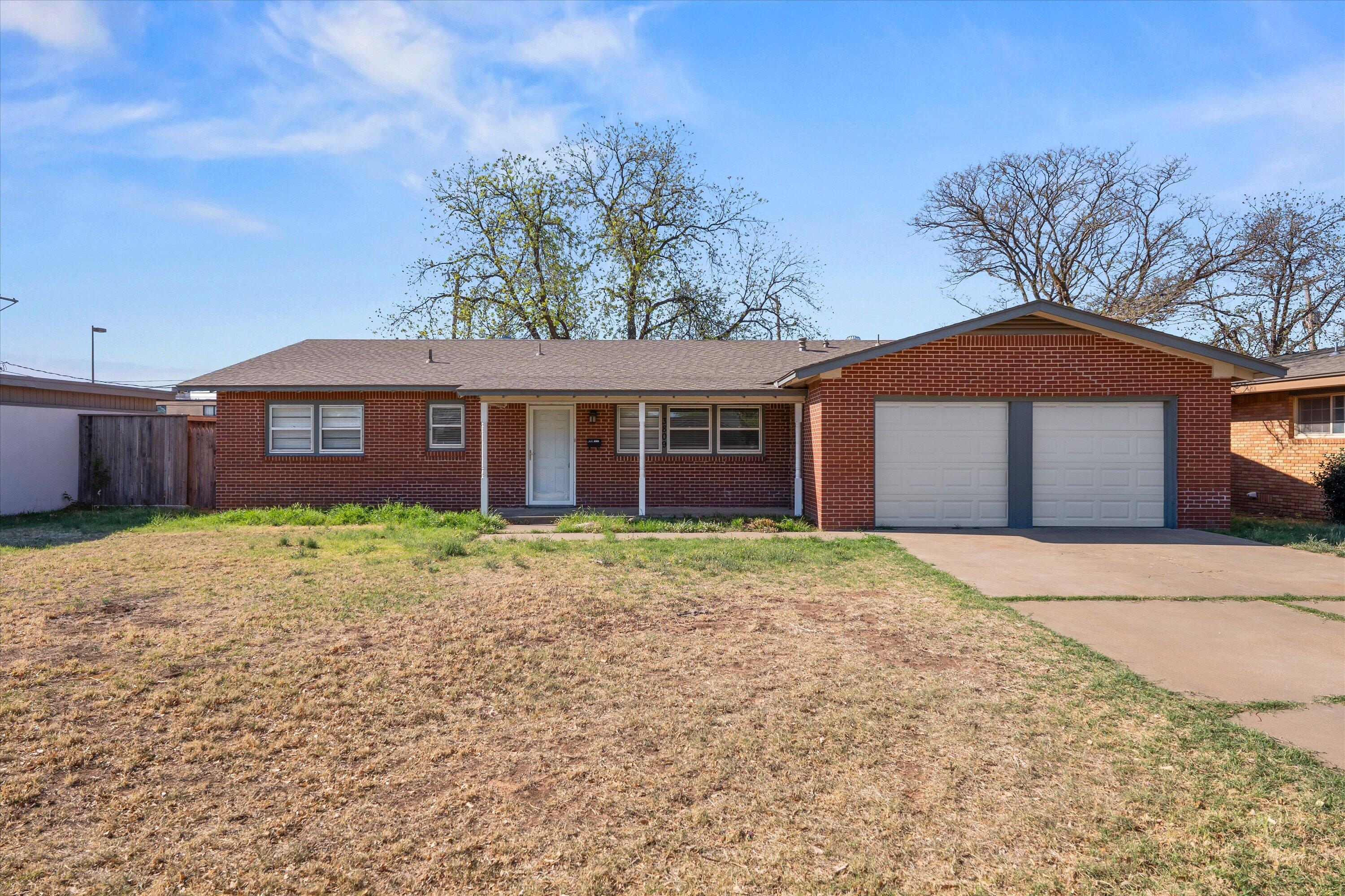 3809 49th Street Lubbock, TX 79413 - Photo 1 of 24 a front view of a house with garden