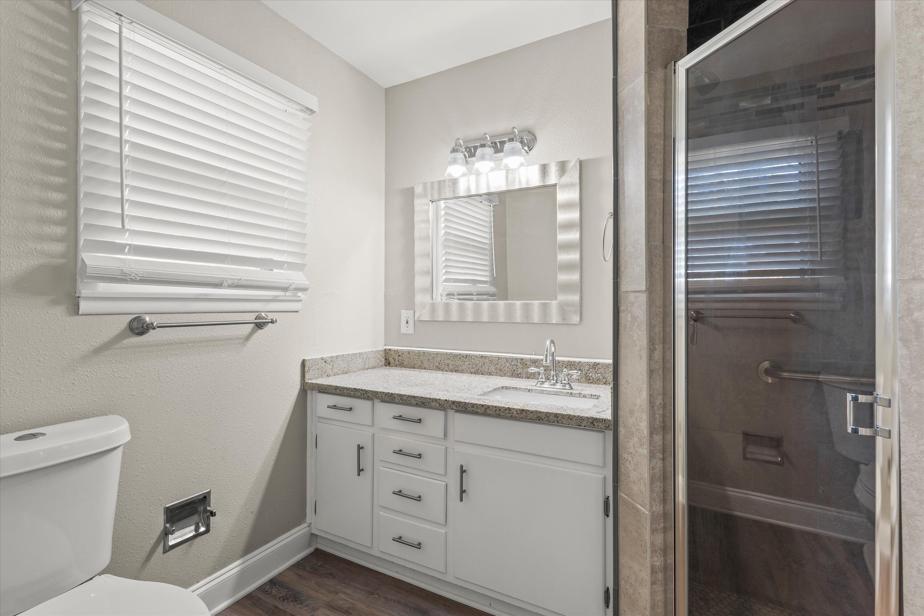 3809 49th Street Lubbock, TX 79413 - Photo 13 of 24 a bathroom with a granite countertop sink toilet and shower