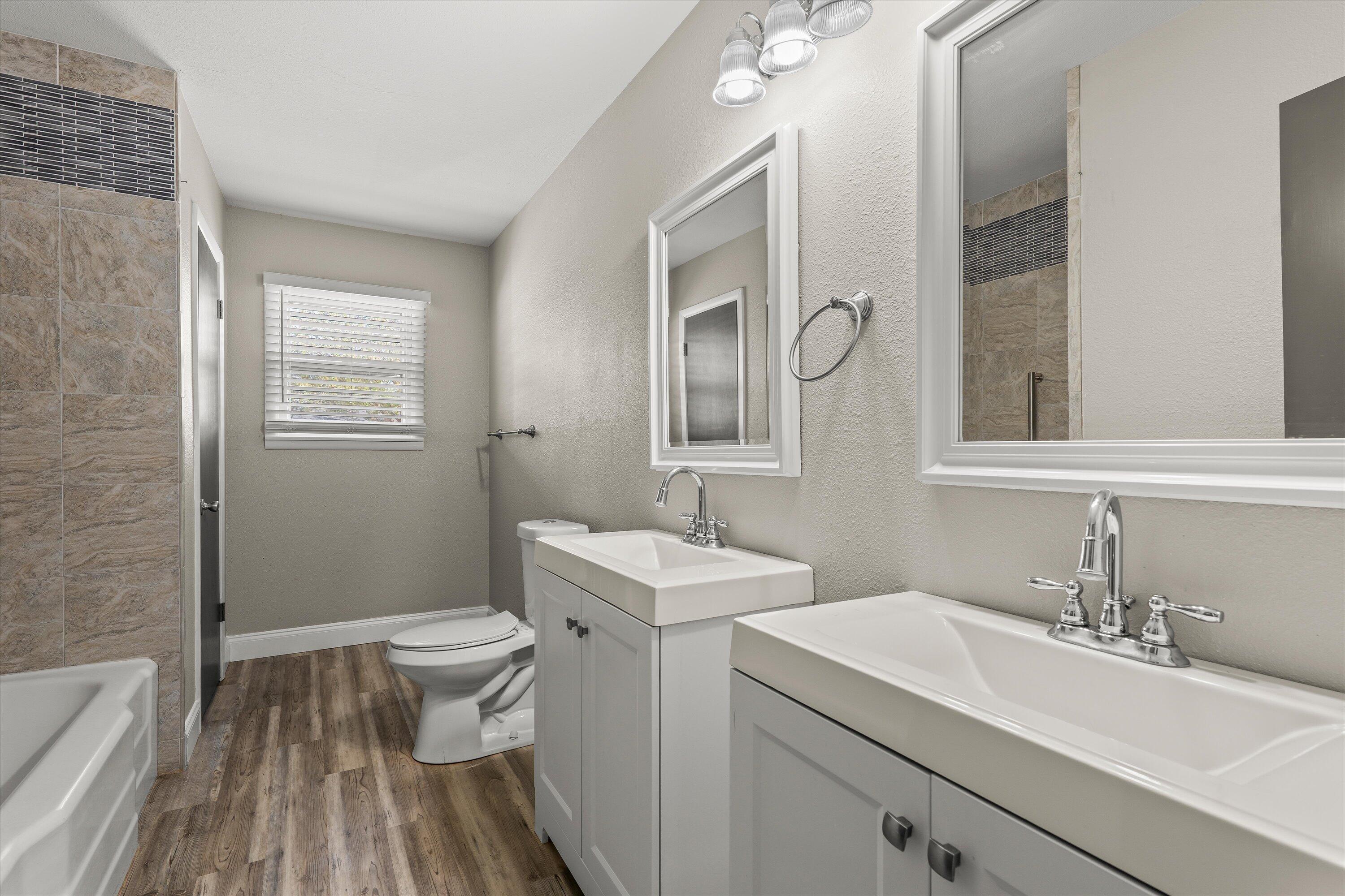 3809 49th Street Lubbock, TX 79413 - Photo 17 of 24 a bathroom with a sink a toilet and mirror