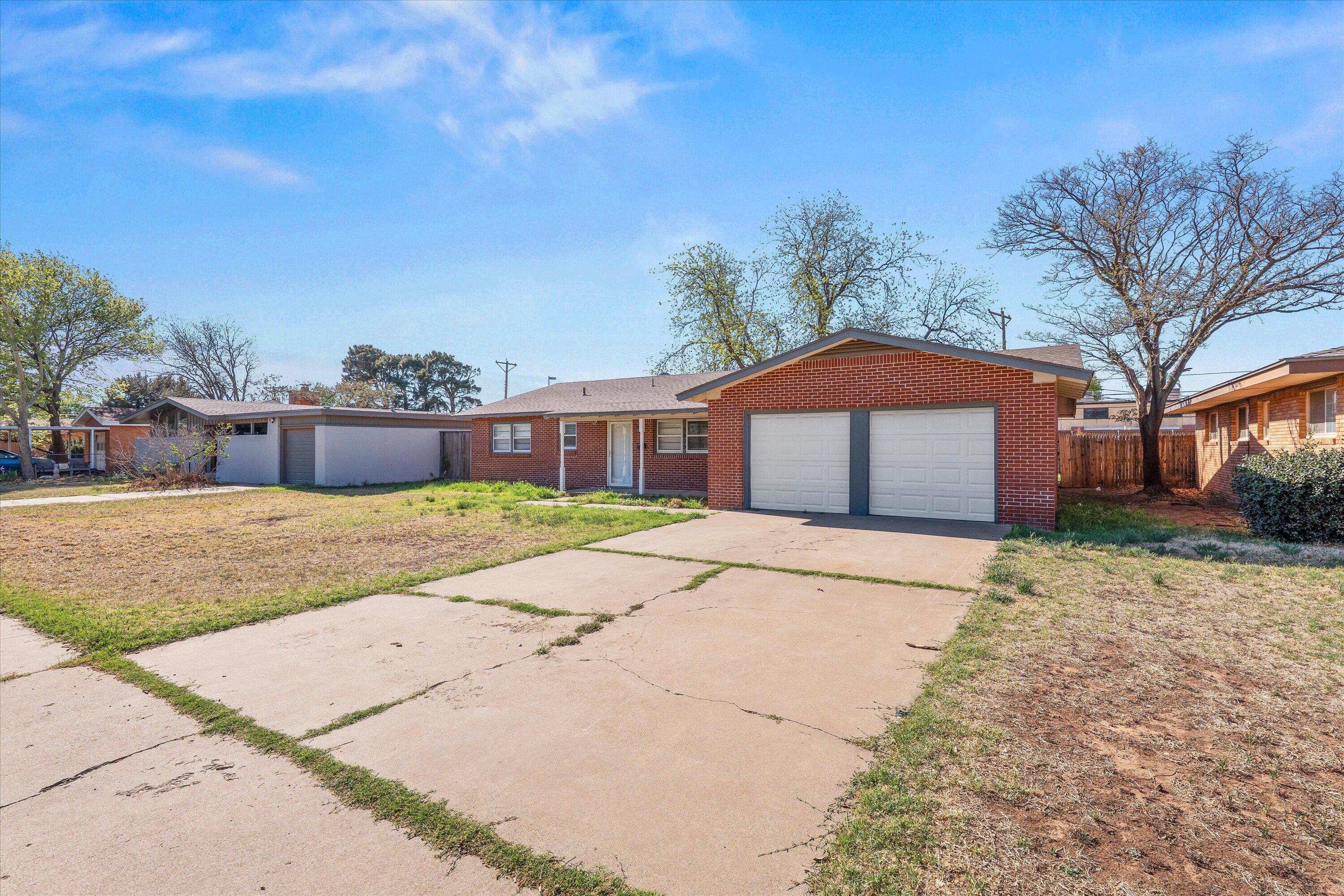 3809 49th Street Lubbock, TX 79413 - Photo 18 of 24 a front view of a house with a yard and garage