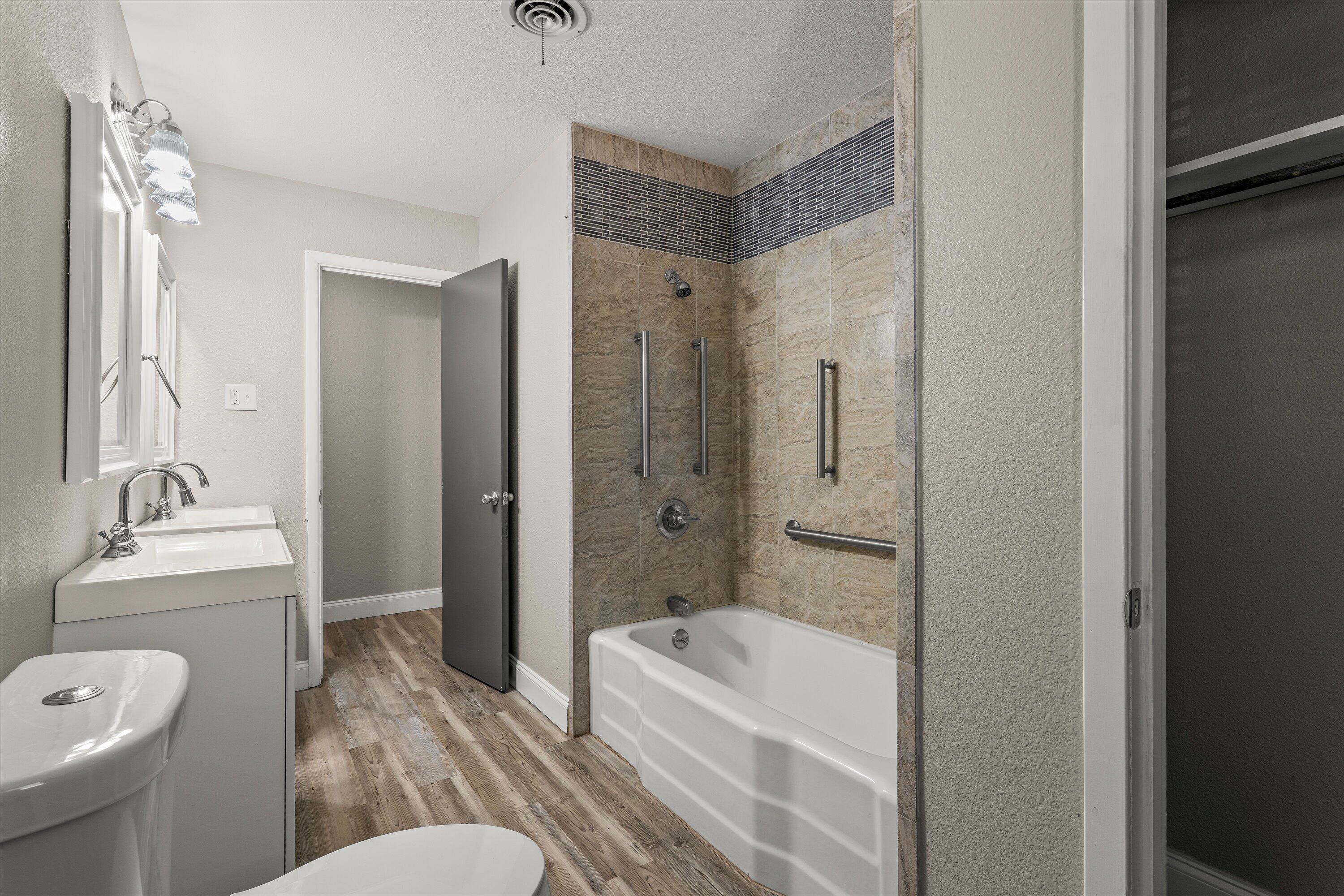 3809 49th Street Lubbock, TX 79413 - Photo 19 of 24 a bathroom with a granite countertop tub sink toilet and mirror