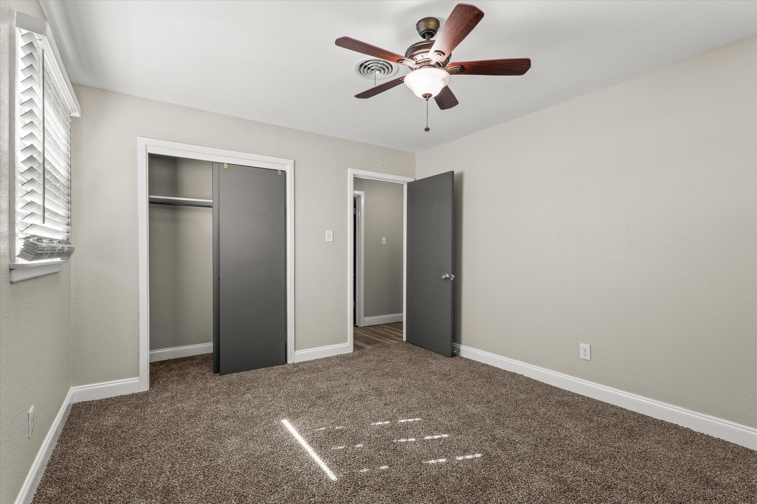 3809 49th Street Lubbock, TX 79413 - Photo 21 of 24 an empty room with a ceiling fan and a window