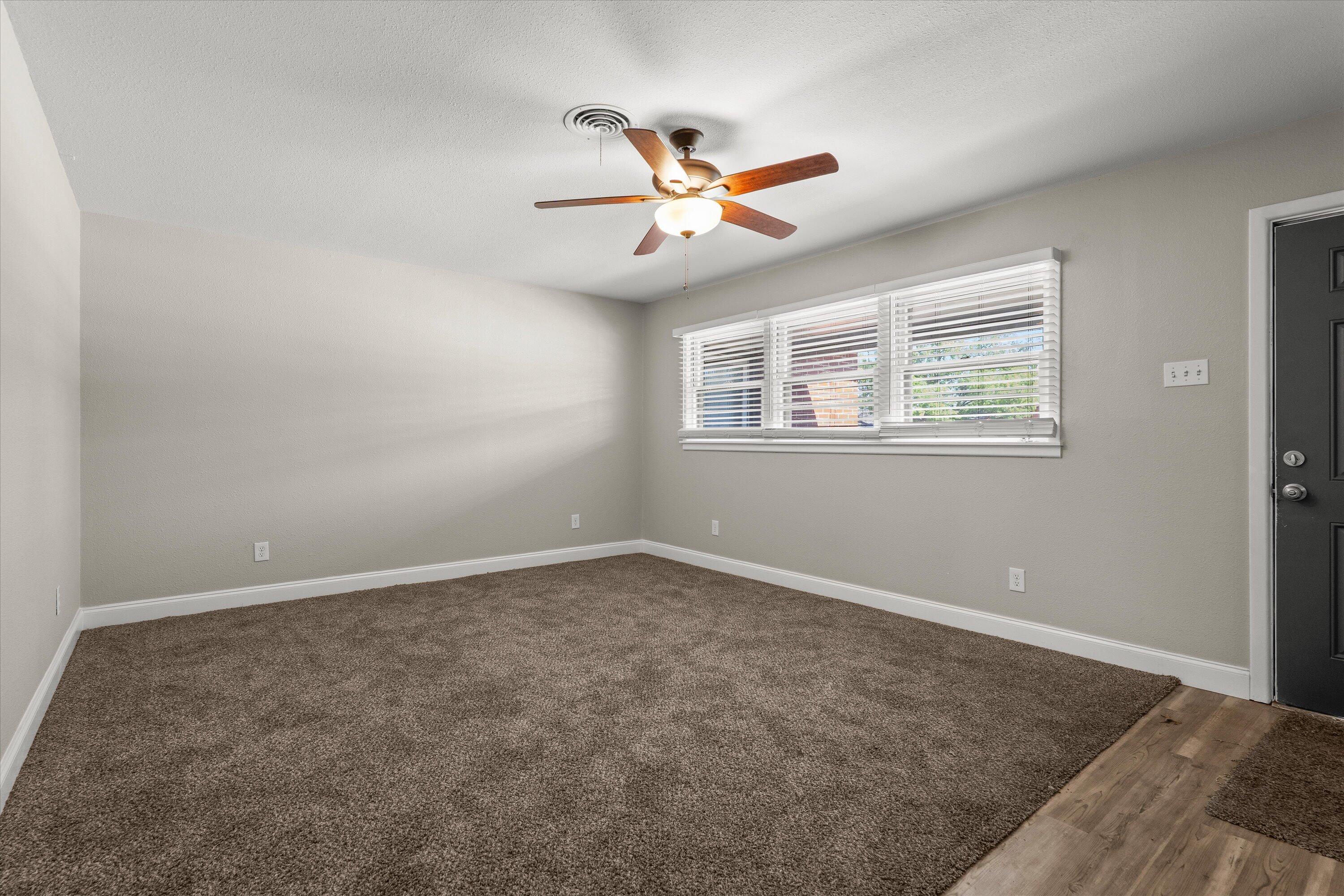 3809 49th Street Lubbock, TX 79413 - Photo 3 of 24 an empty room with windows and ceiling fan