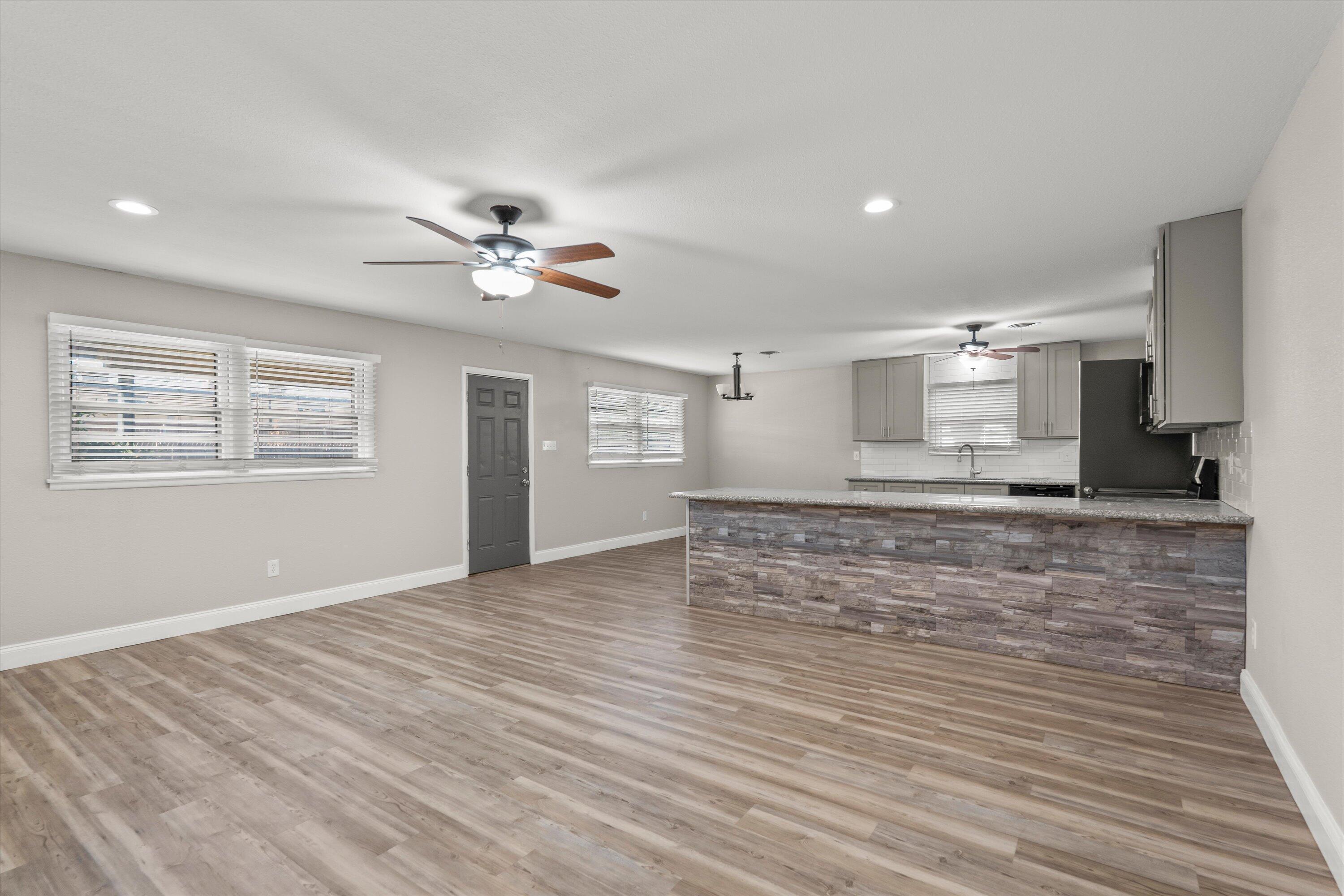 3809 49th Street Lubbock, TX 79413 - Photo 5 of 24 a view of an empty room with kitchen and window