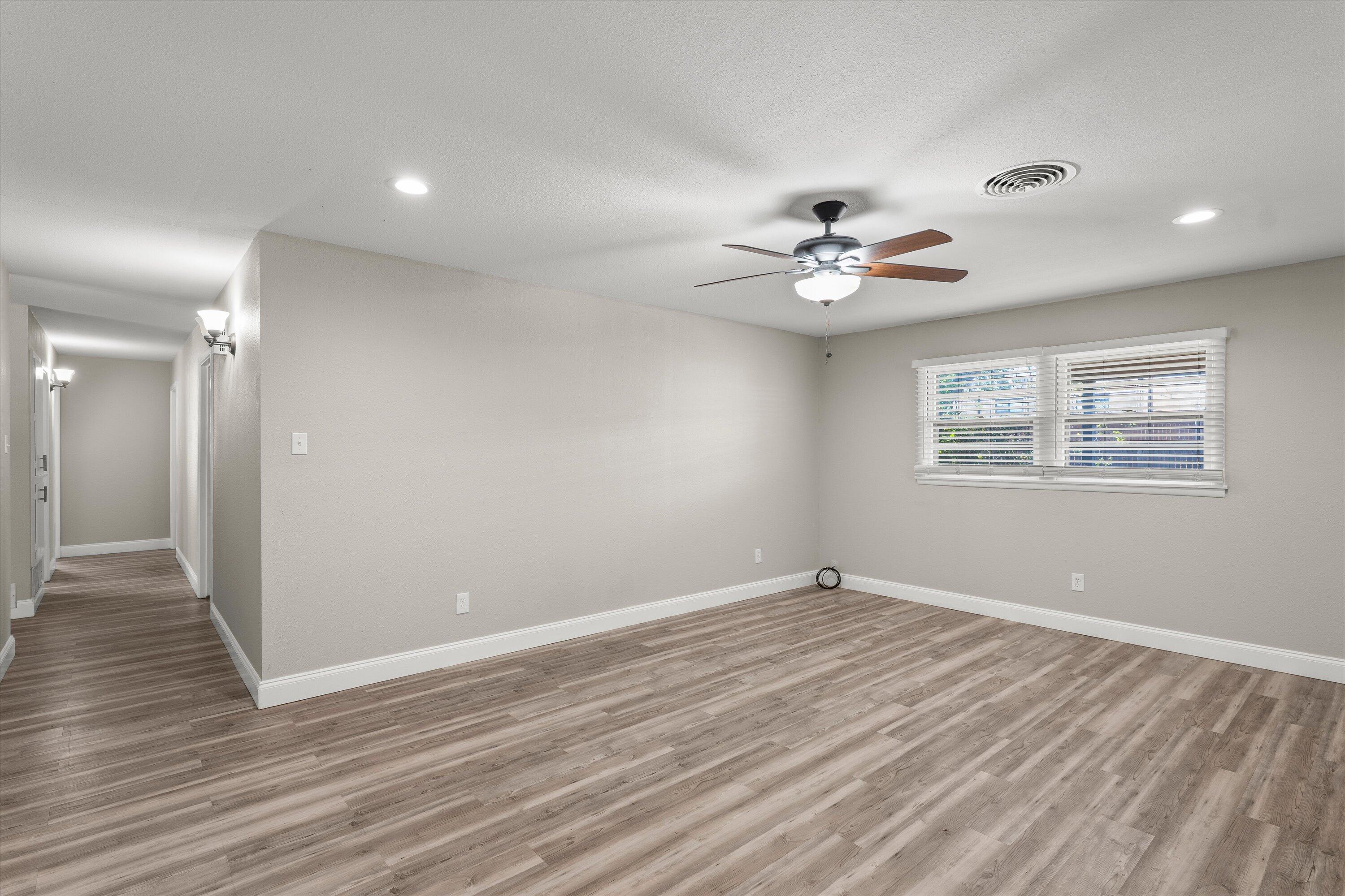 3809 49th Street Lubbock, TX 79413 - Photo 9 of 24 wooden floor in an empty room with a window