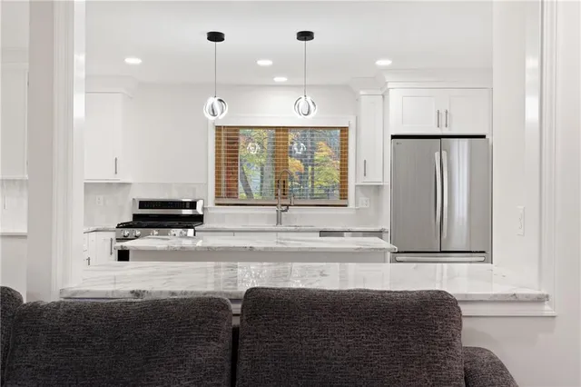 a kitchen with stainless steel appliances granite countertop a refrigerator and a stove