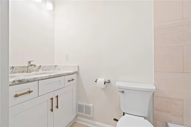 a bathroom with a granite countertop toilet and sink